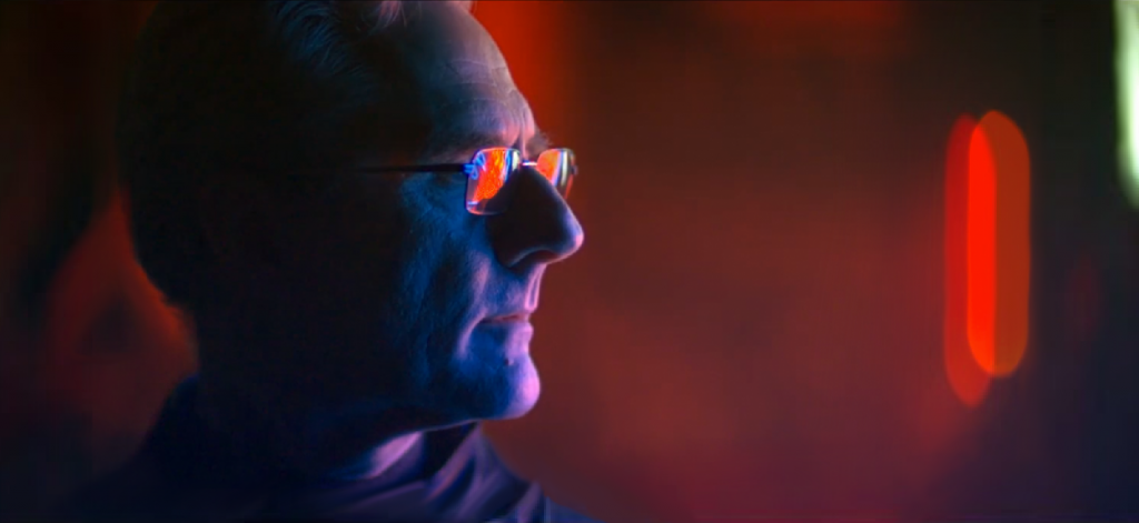 Zdjęcie przedstawia profil Marka Bilińskiego w oświetleniu czerwonego, fioletowego i zielonego neonu